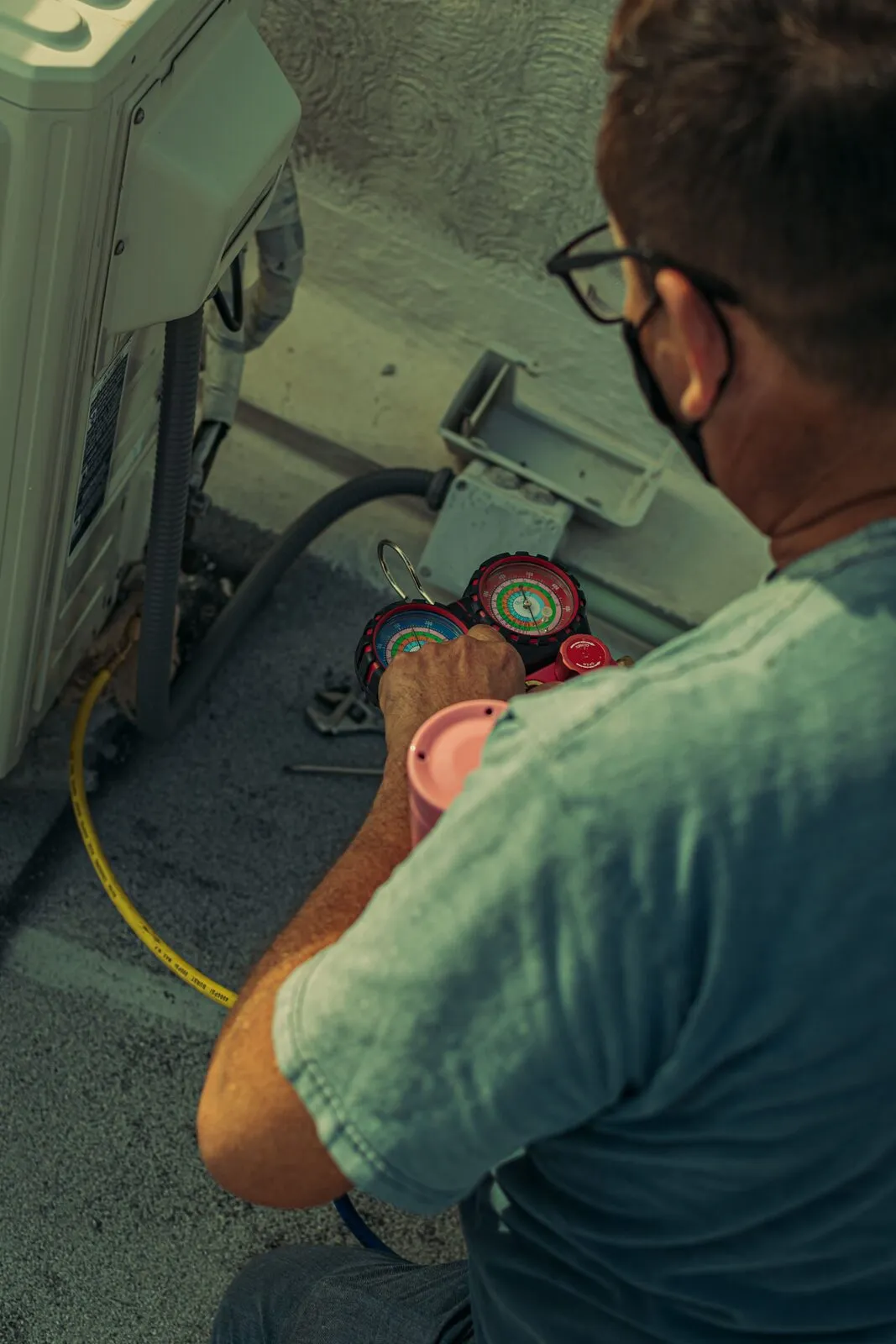 Illustrative stock photo — a technician checking refrigerant gauges on an outdoor AC unit; not an actual Lake Havasu AC Guide job site.
